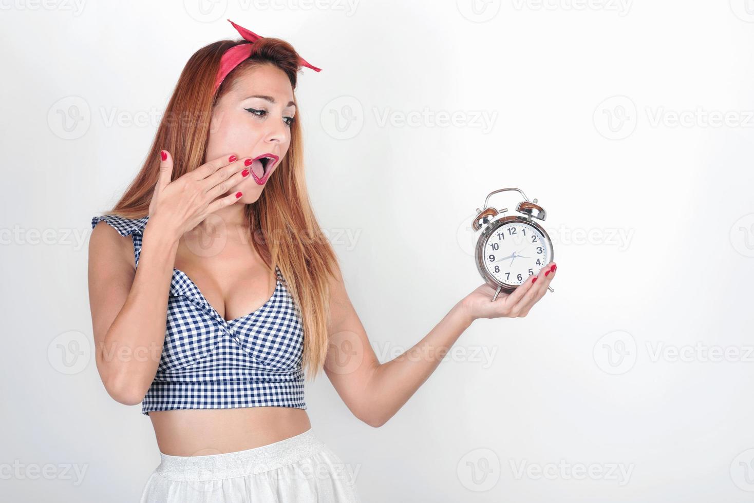 mulher jovem surpresa com um despertador foto