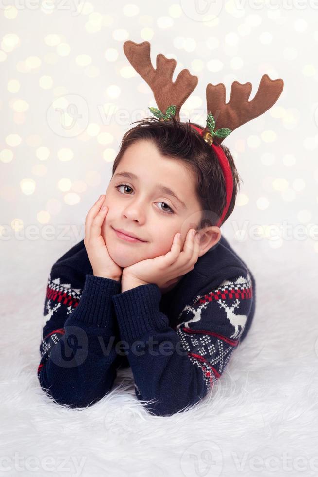 criança feliz vestindo renas no natal foto