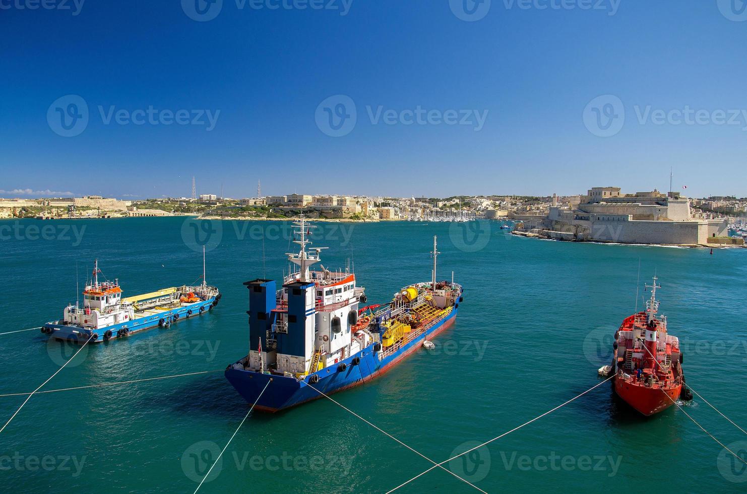 três navios de carga coloridos no porto de valletta, malta foto
