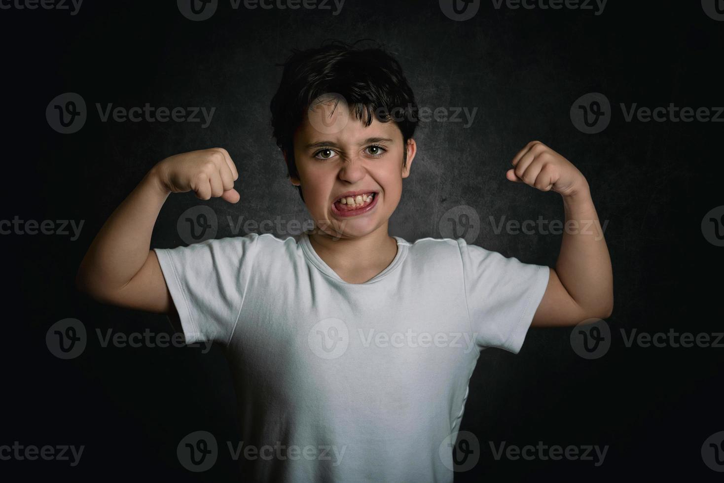 garoto forte mostrando os músculos de seus braços foto