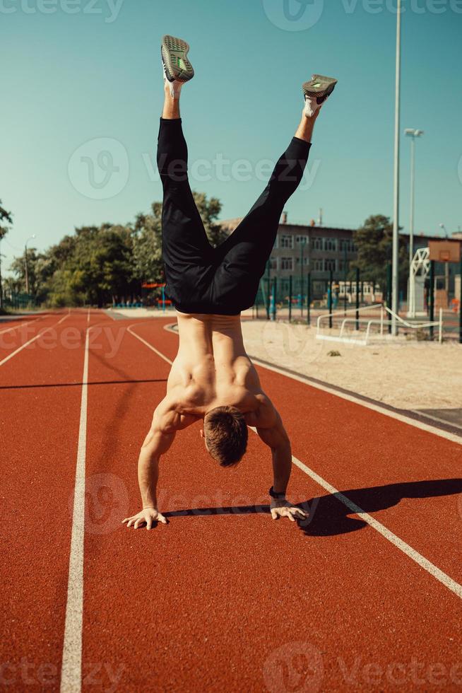 cara de esportes jovem fica em seus braços foto