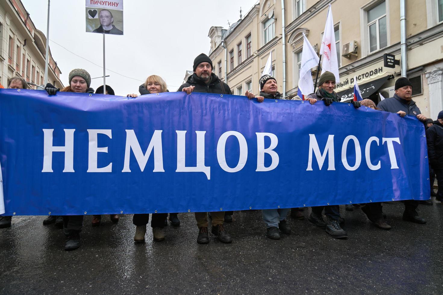 moscou, rússia - 24 de fevereiro de 2019 marcha memorial nemtsov. manifestantes carregando uma grande bandeira ponte nemtsov - requisito para as autoridades nomearem seu nome a ponte em que ele foi morto foto