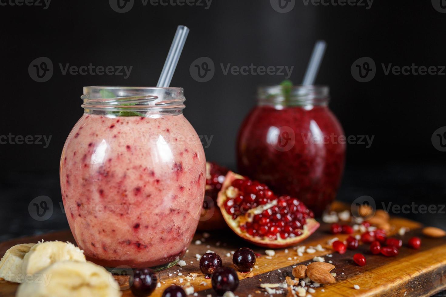 smoothies preparados na hora de banana com romã e banana com amora em garrafa. dieta, estilo de vida saudável foto