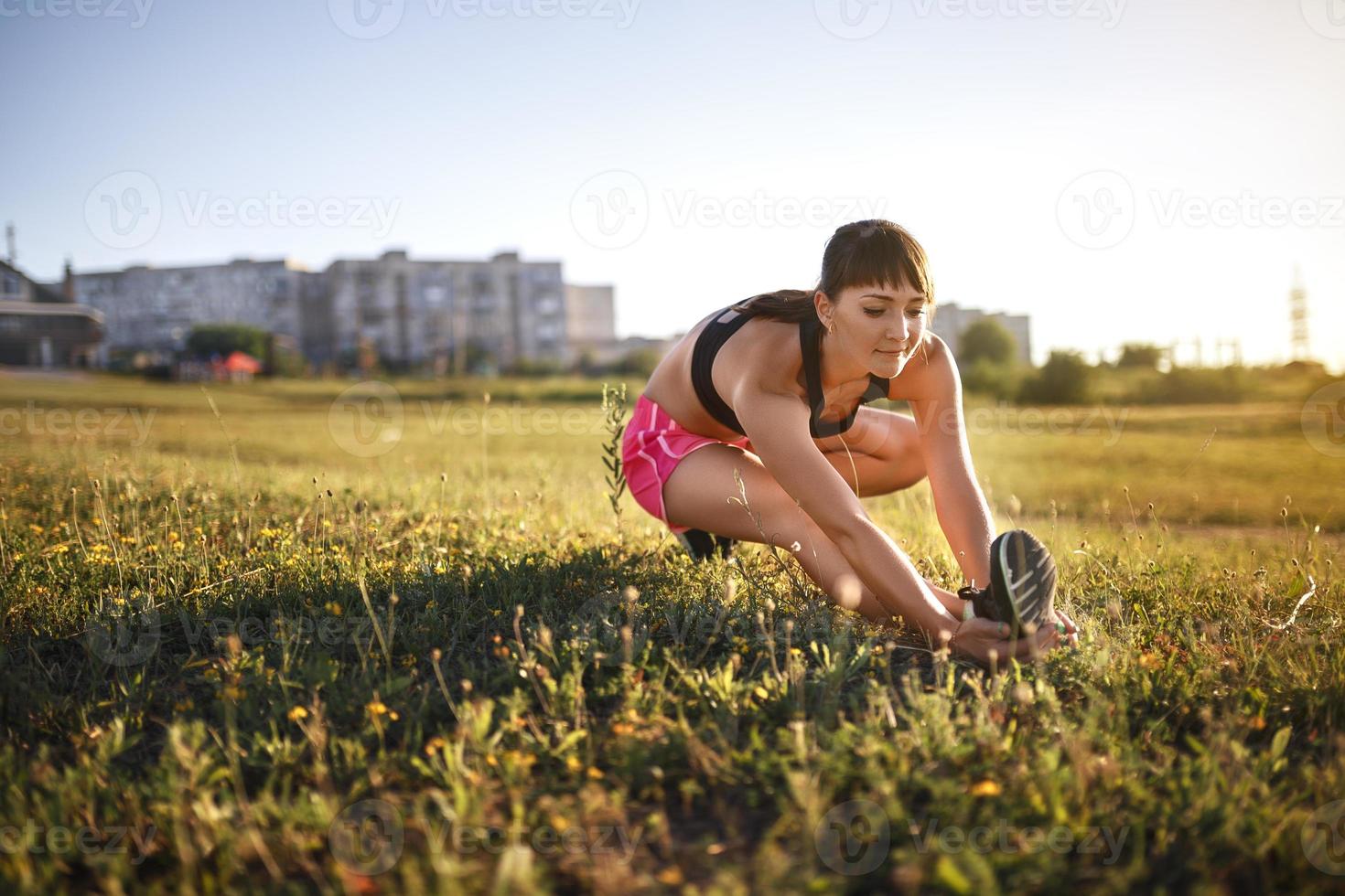 mulher jovem esportiva esticando e se preparando para correr. foto