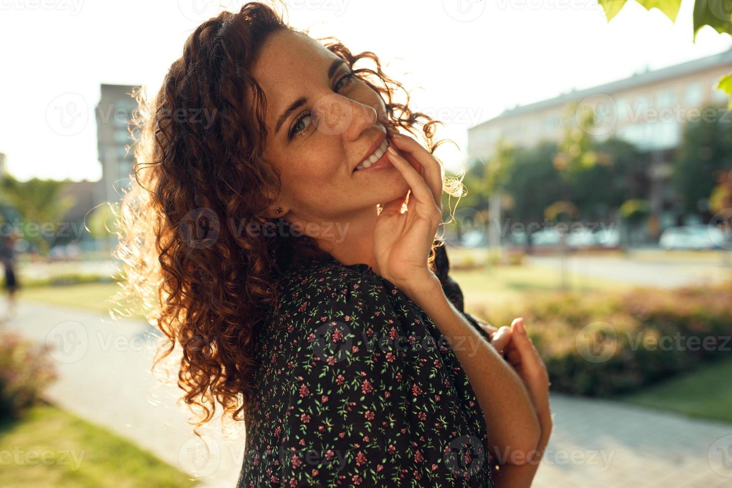 retratos de uma encantadora garota ruiva com sardas e um rosto bonito. a garota posa para a câmera no centro da cidade. ela tem um ótimo humor e um sorriso doce foto