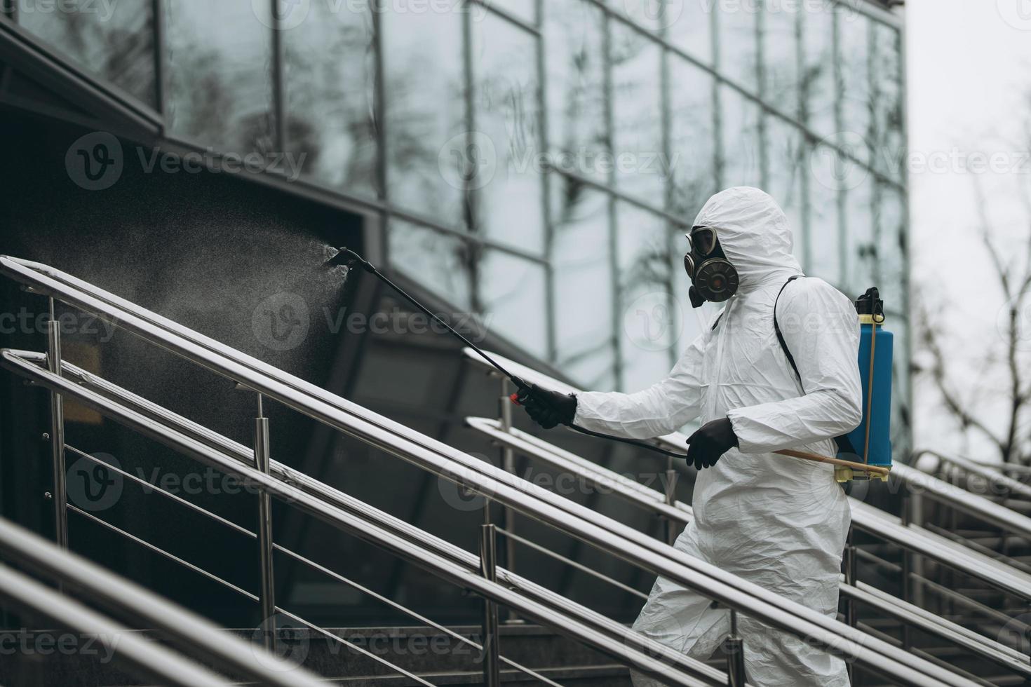 limpeza e desinfecção no complexo da cidade em meio à epidemia de coronavírus equipes profissionais para esforços de desinfecção prevenção de infecções e controle de traje e máscara de proteção epidêmica foto