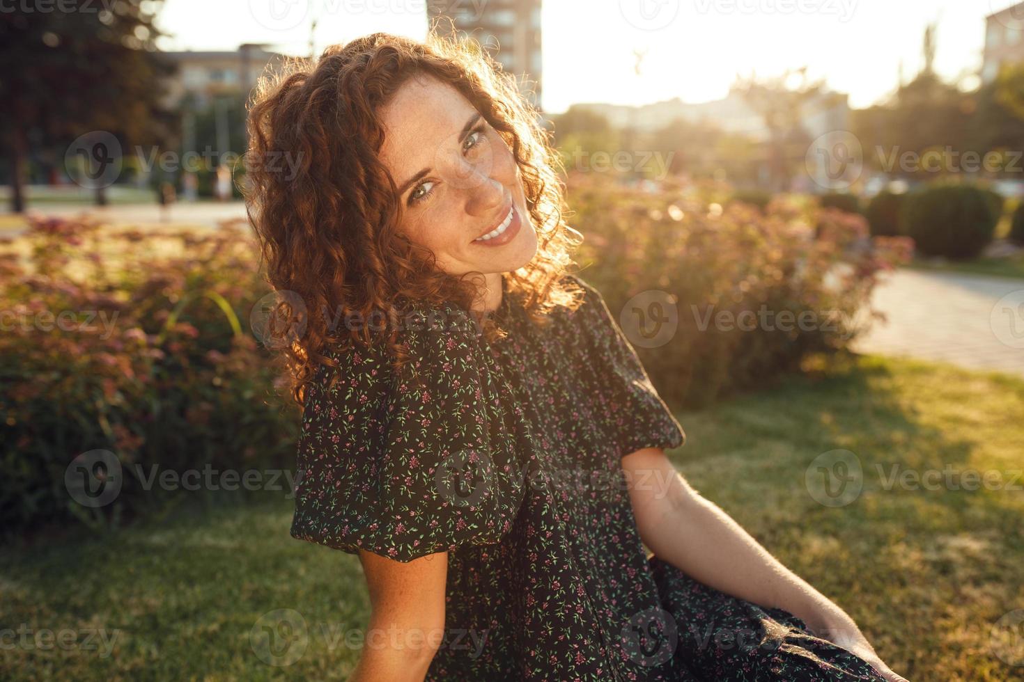 encantadora garota ruiva encaracolada com sardas em poses de vestido para a câmera no centro da cidade mostrando diferentes emoções faciais foto