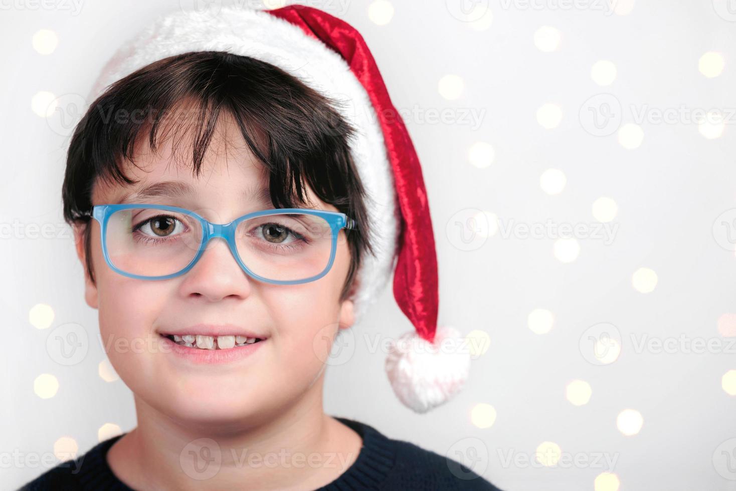 menino feliz com óculos no natal em fundo branco foto