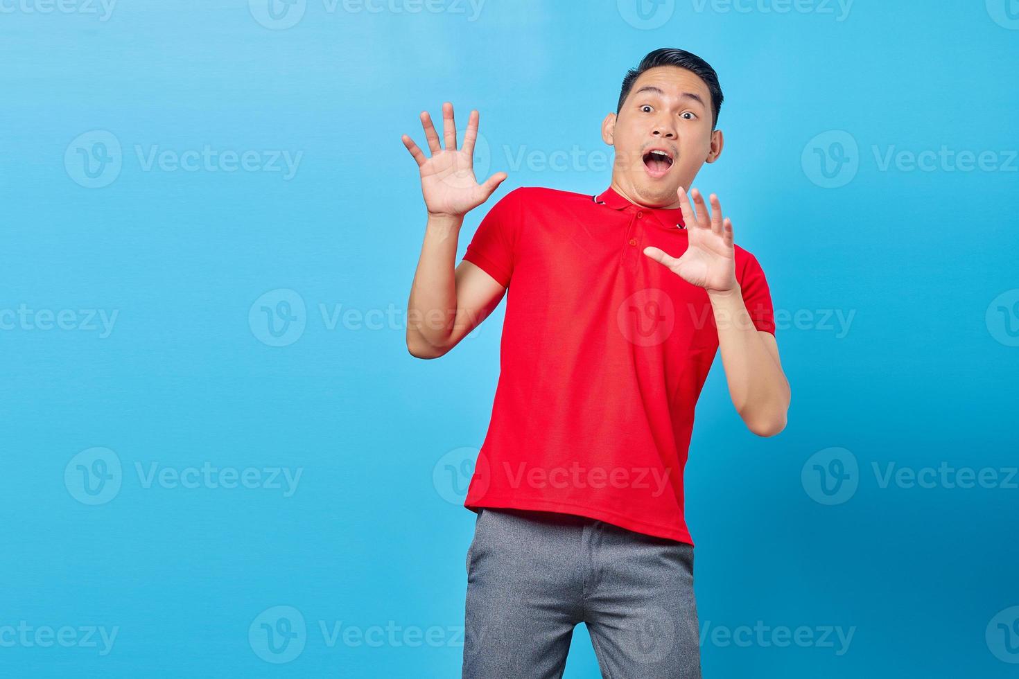 retrato de jovem asiático bonito olhando para o espaço de cópia com expressão de surpresa olhando grande promo isolada em fundo azul foto