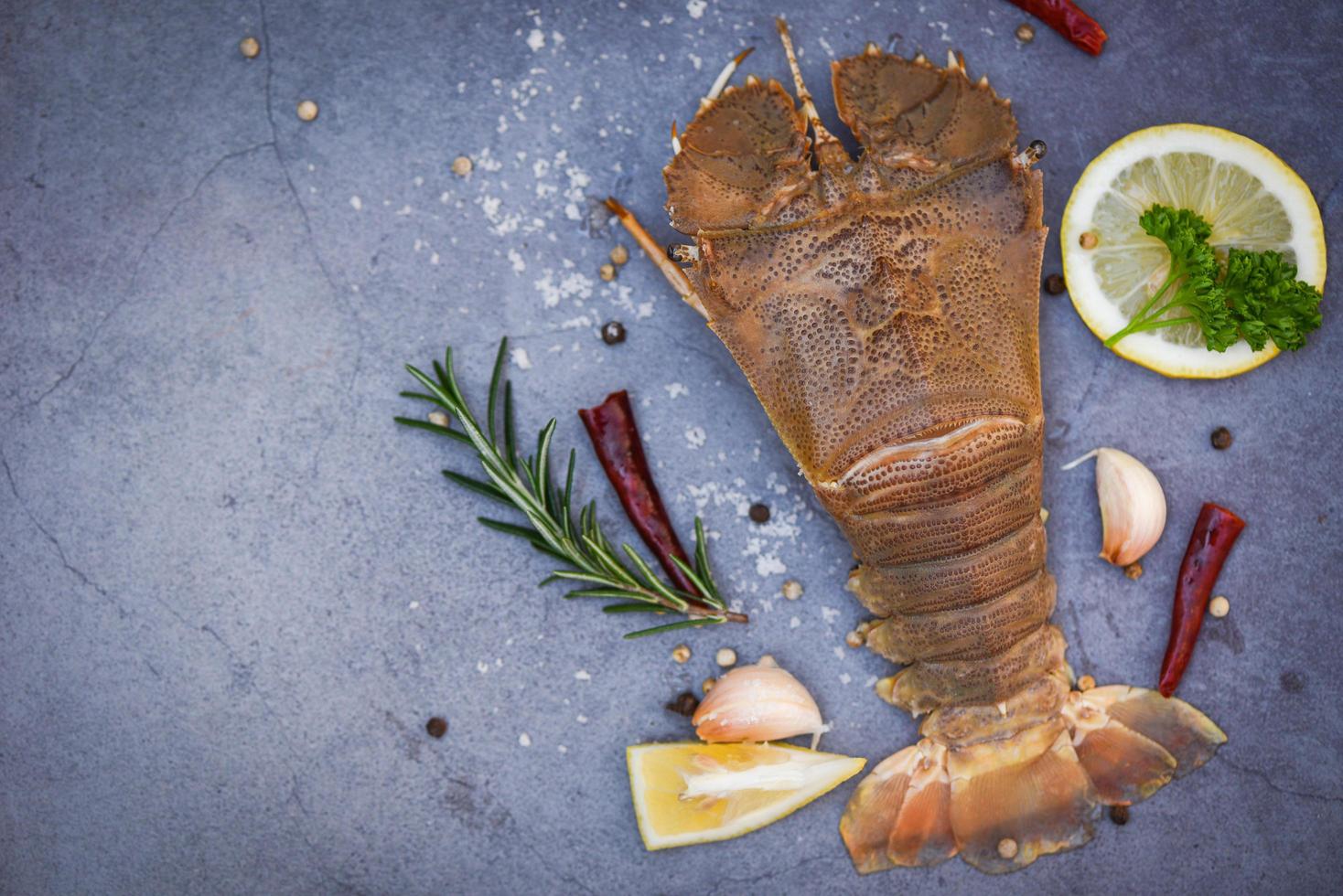 camarões de lagosta de cabeça chata crua com ervas e especiarias, lagosta de chinelo fresco para cozinhar em fundo escuro no restaurante de frutos do mar ou mercado de frutos do mar, lagosta moreton bay bug foto