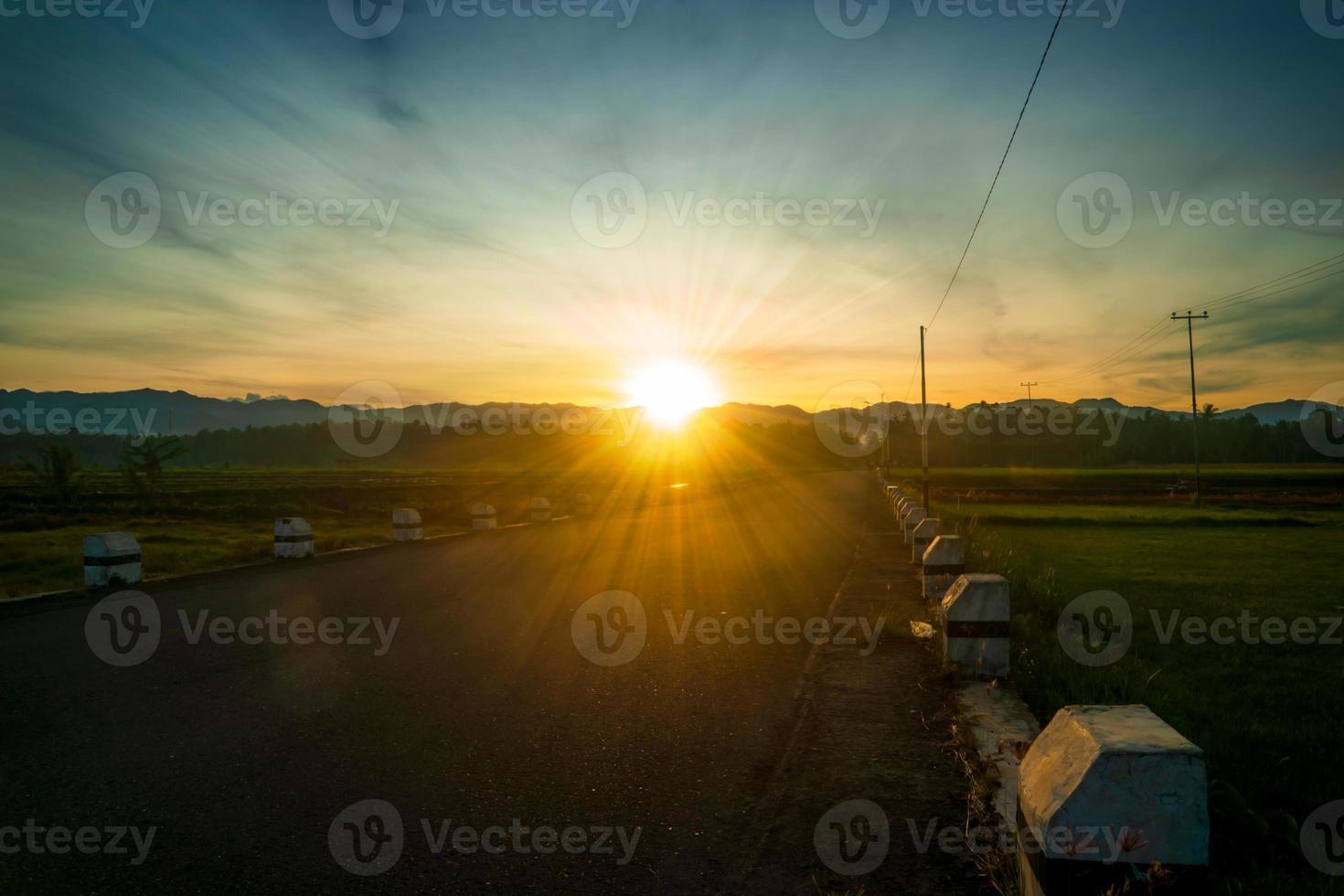 paisagem de manhã rural com estrada vazia e nascer do sol foto