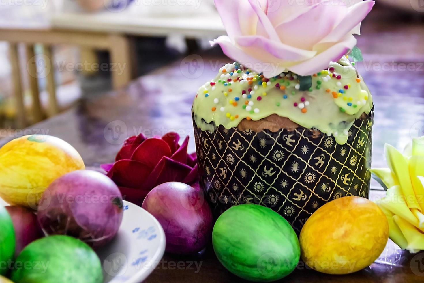 bolos de páscoa doces com ovos coloridos na mesa no quarto foto