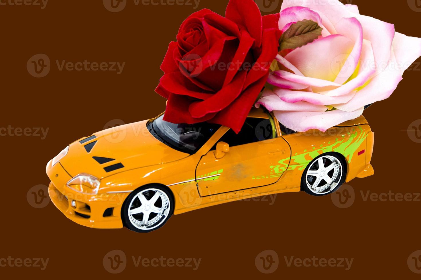 carro de brinquedo com rosas em fundo marrom foto