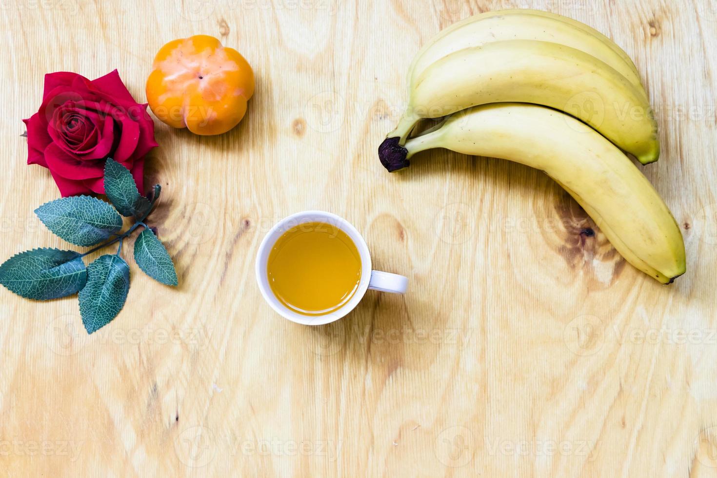 banana fresca e caqui no fundo da parede de tijolos e mesa de madeira, foto