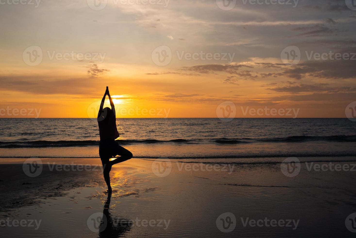 silhueta de homem meditar na praia ao pôr do sol foto