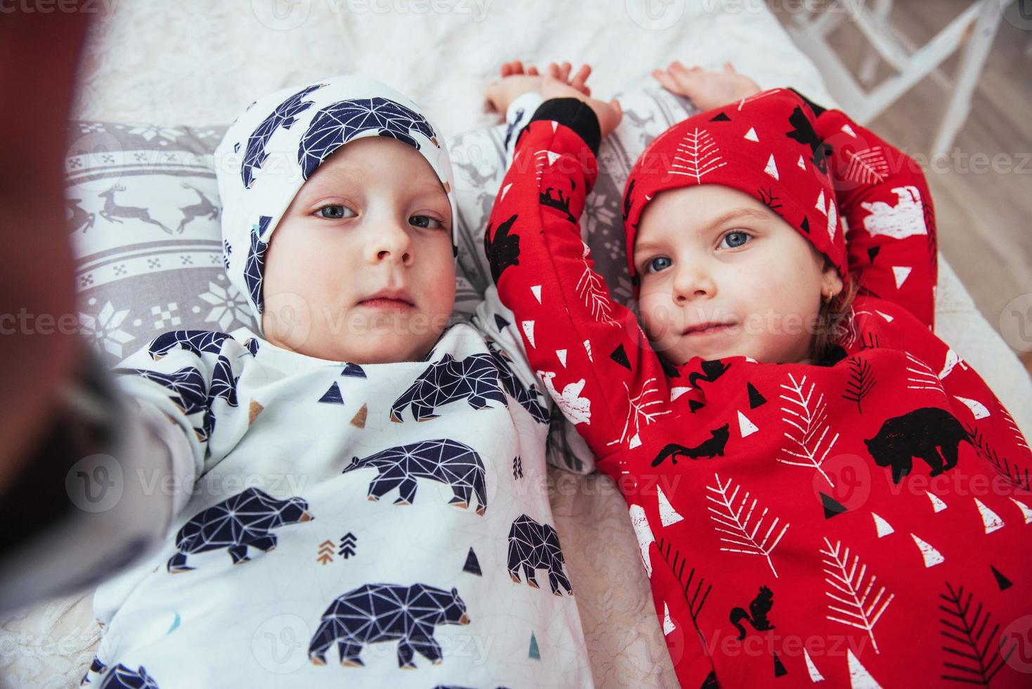 criança de pijama macio e quente brincando na cama foto