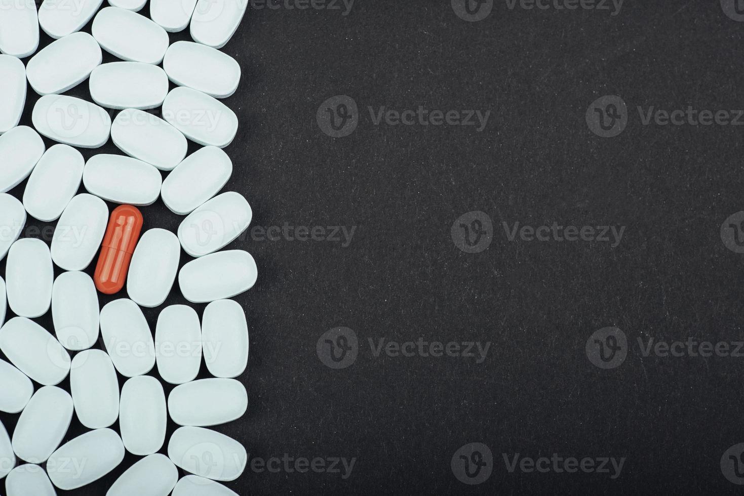 comprimidos brancos médicos ou suplementos para o tratamento e cuidados de saúde em um fundo preto foto