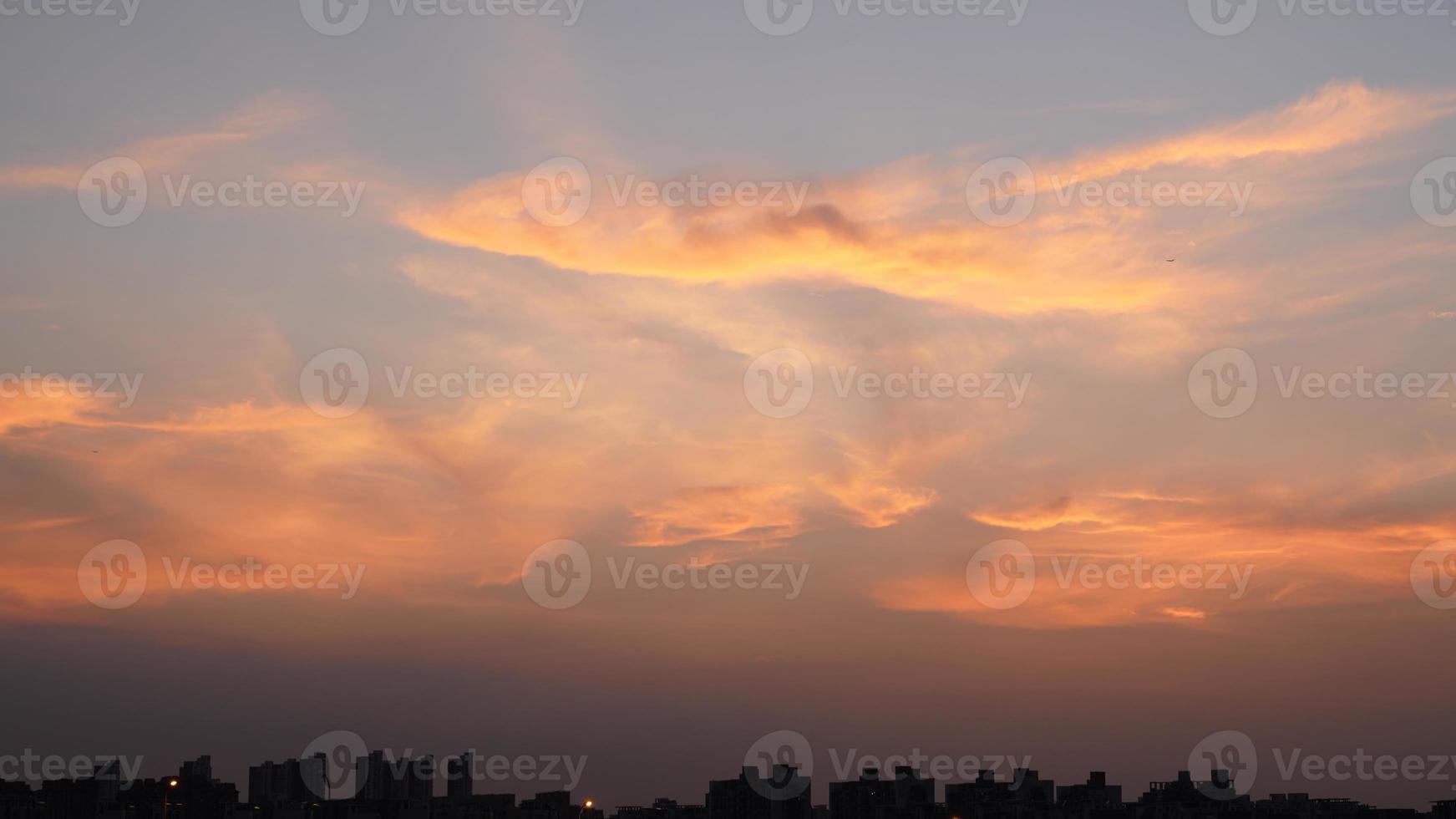 a bela vista do pôr do sol com a silhueta e o céu de nuvens coloridas na cidade foto