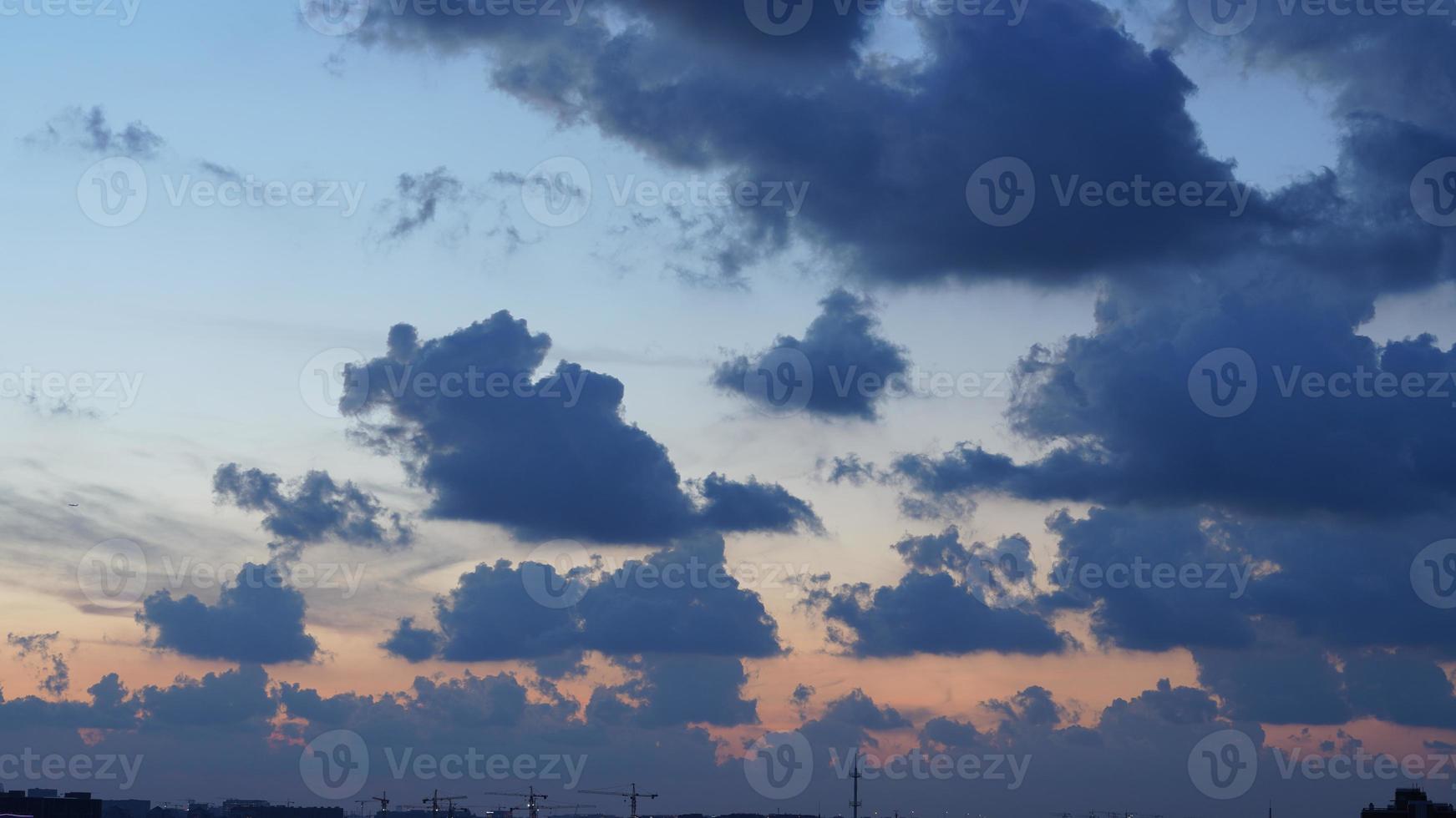 a bela vista do pôr do sol com a silhueta e o céu de nuvens coloridas na cidade foto