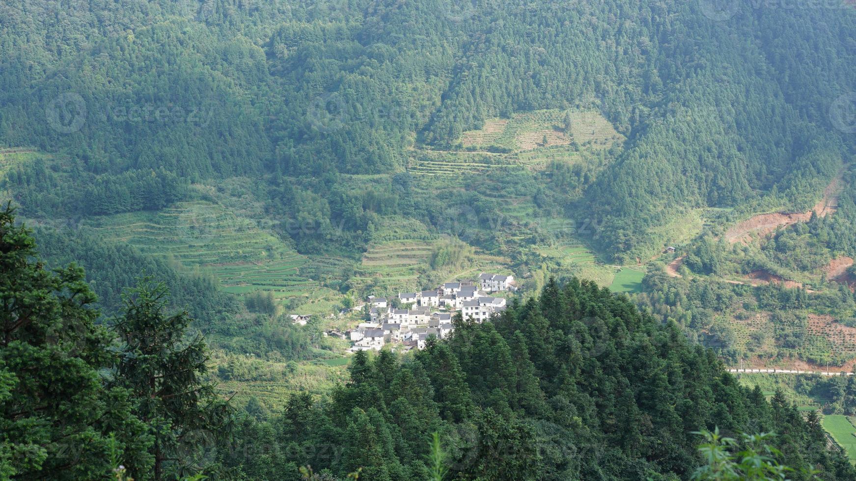 as belas paisagens de montanhas com a floresta verde e a pequena vila como pano de fundo no interior da China foto