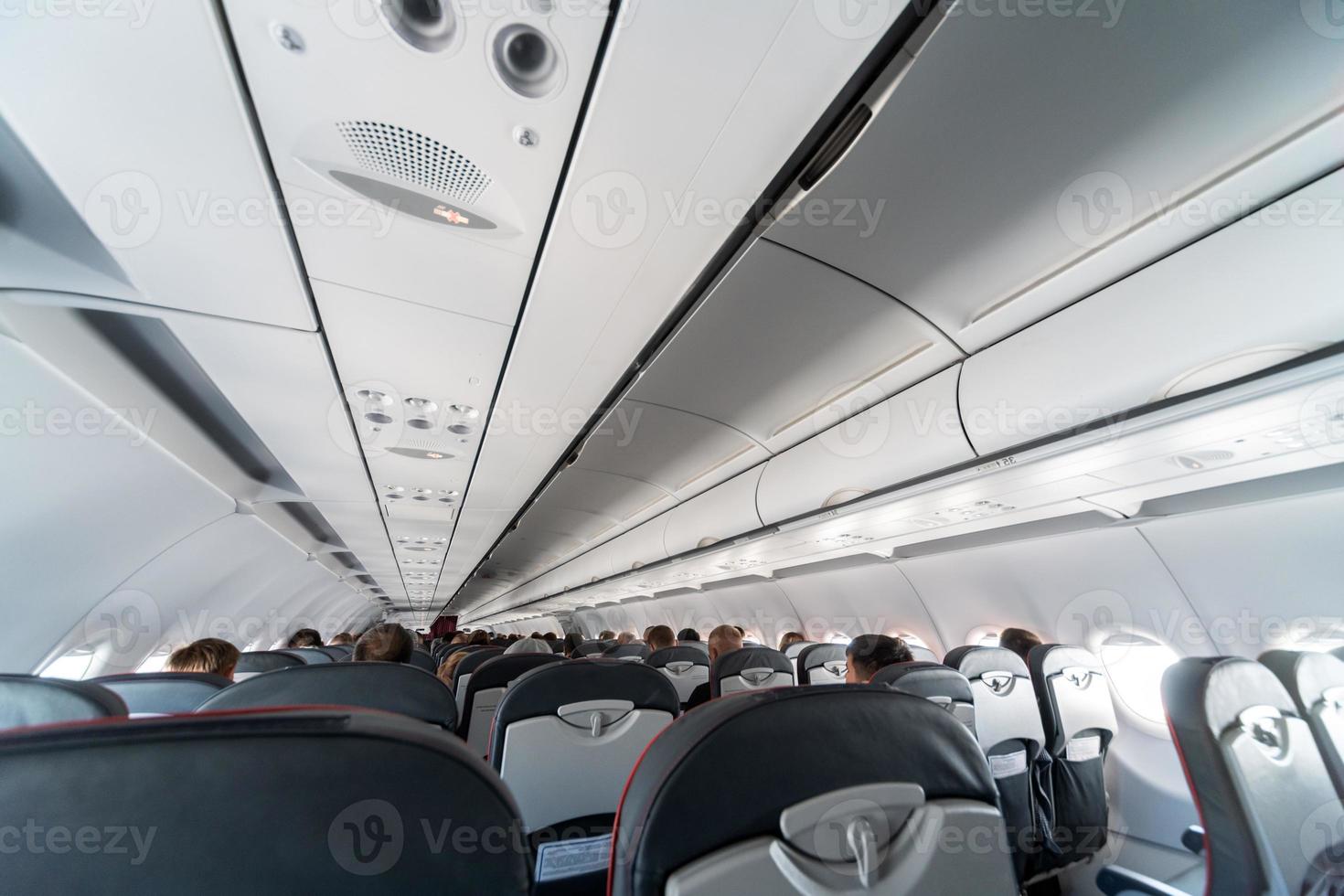 painel de controle do ar condicionado do avião sobre os assentos, ar abafado na cabine da aeronave com pessoas, nova companhia aérea de baixo custo foto