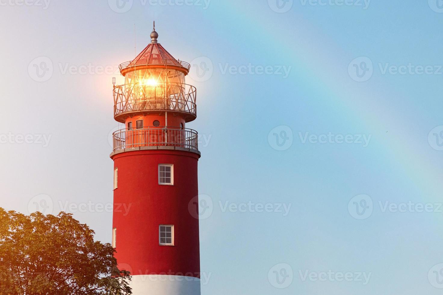 farol no porto de baltiysk, lindo arco-íris e luzes de farol, céu azul limpo foto