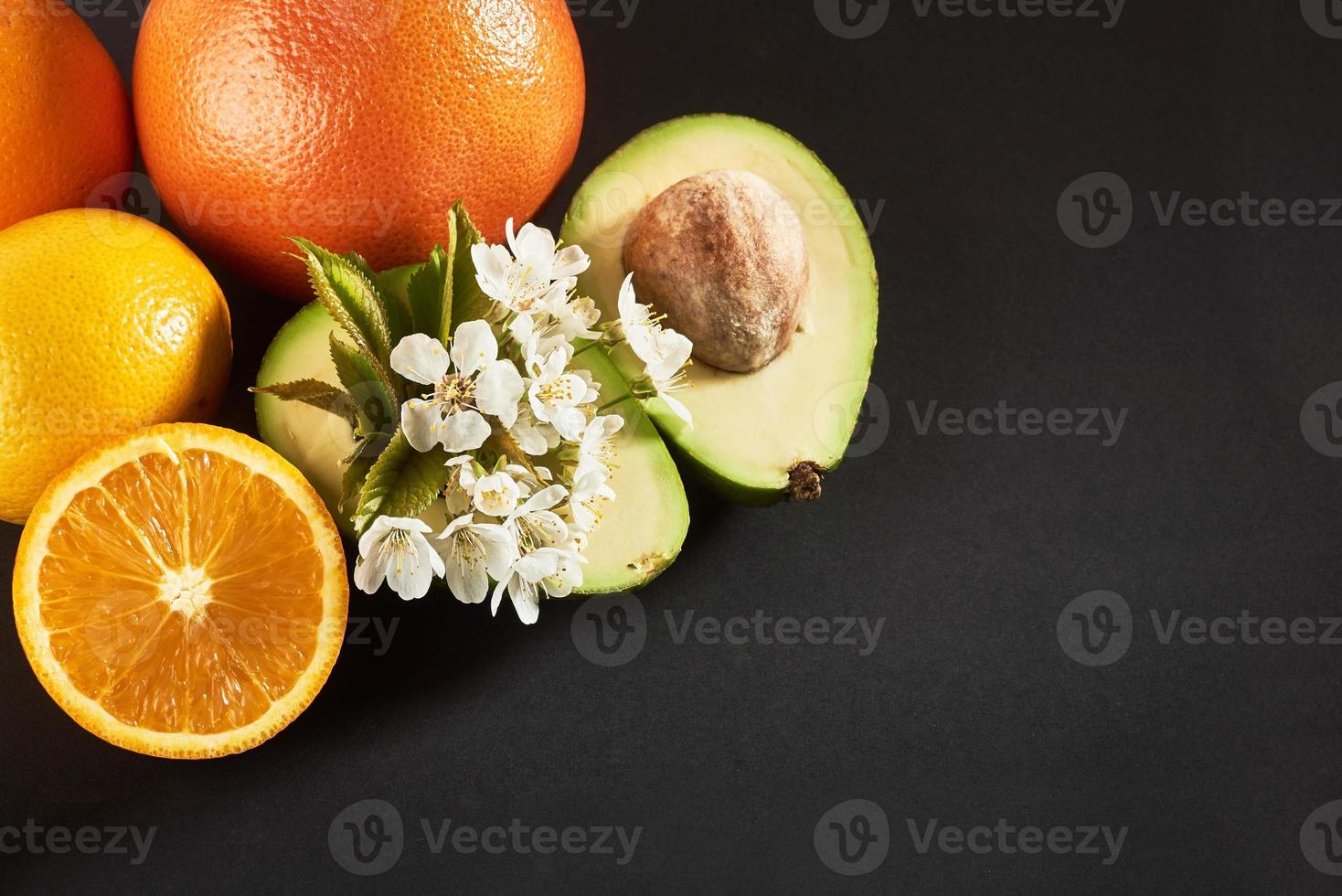 toranja, laranja e abacate, isolados em um fundo preto foto