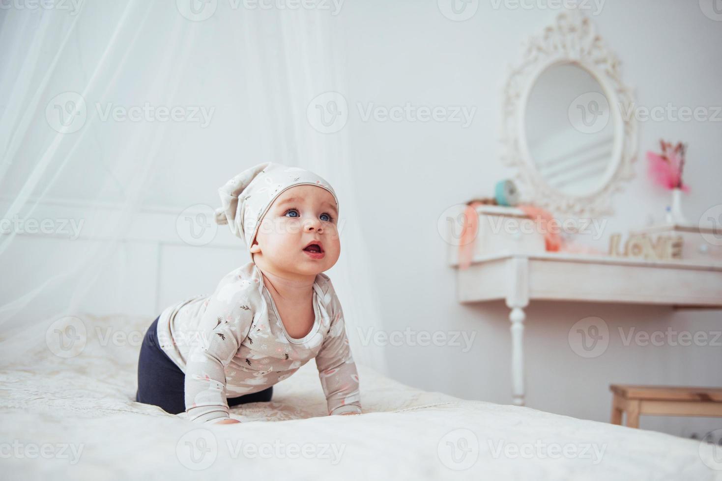 bebê recém-nascido vestido de terno em uma cama macia no estúdio. foto