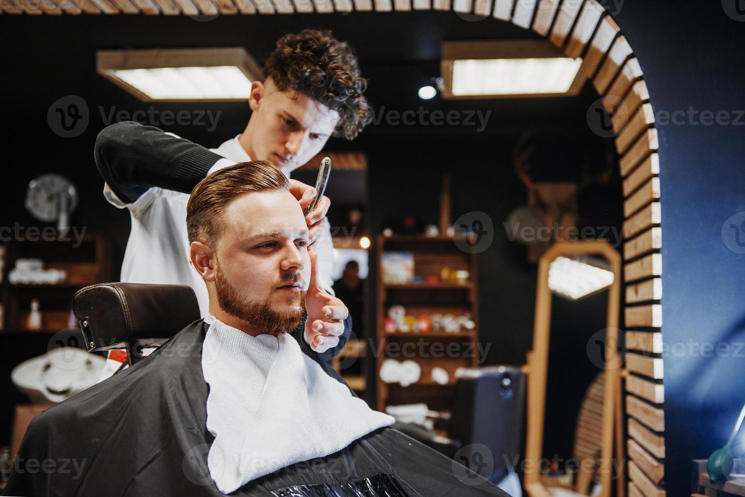 penteado e corte de cabelo masculino em uma barbearia ou salão de cabeleireiro. foto