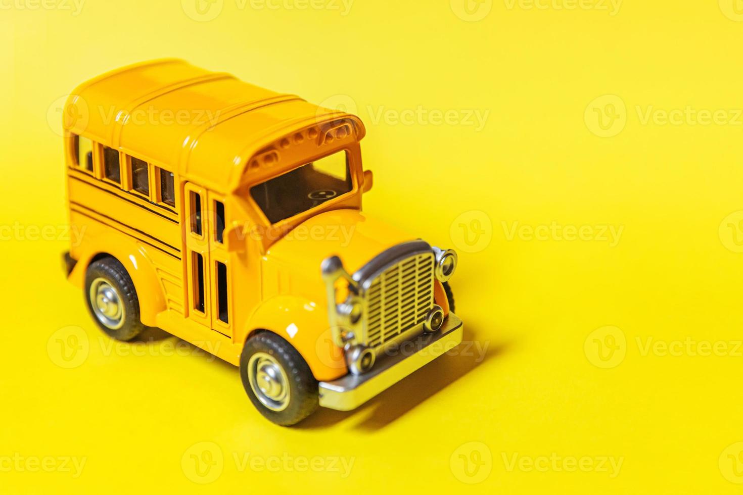 simplesmente projete o ônibus escolar amarelo do carro clássico do brinquedo isolado no fundo colorido amarelo. transporte diário de segurança para crianças. de volta ao conceito de escola. símbolo de educação, copie o espaço foto