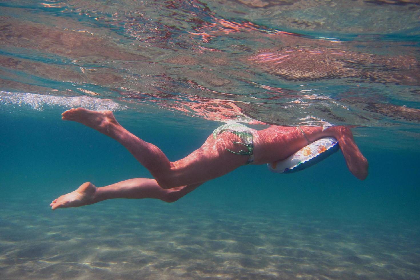 mulher de biquíni flutuando no mar foto