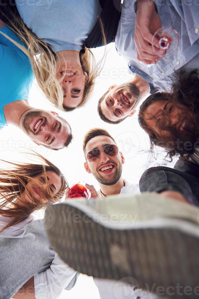 férias de verão, pessoas felizes - um grupo de adolescentes olhando para baixo com um sorriso feliz no rosto. foto