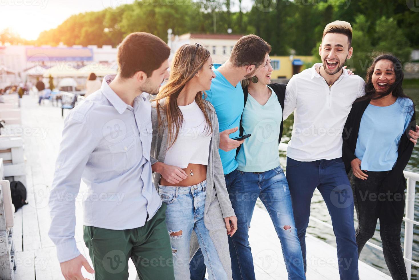 grupo de jovens sorridentes e bem sucedidos de férias na doca foto