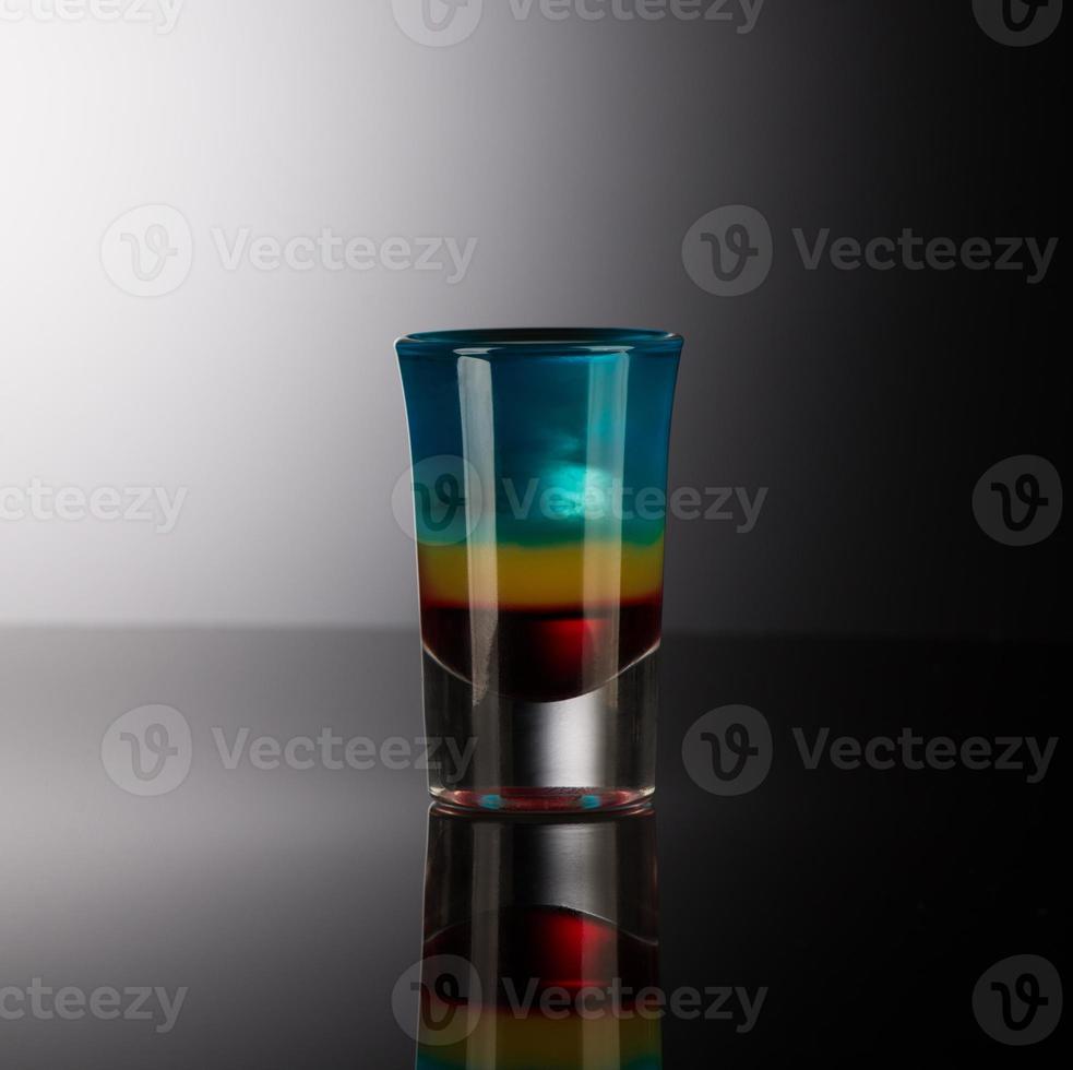 copo com álcool em um fundo escuro foto