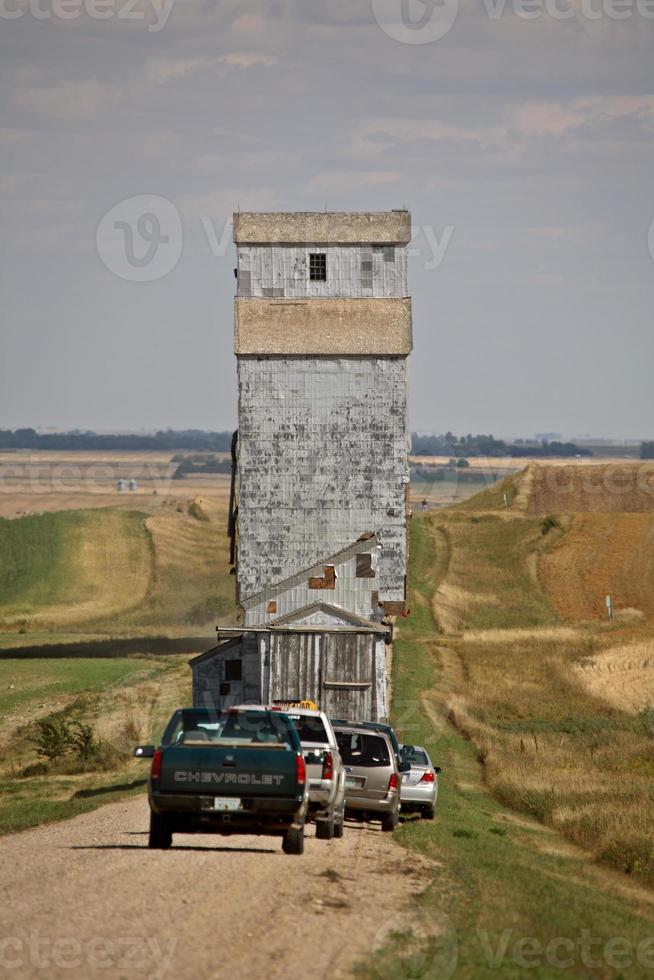 elevador de grãos sendo movido ao longo da estrada rural de saskatchewan foto