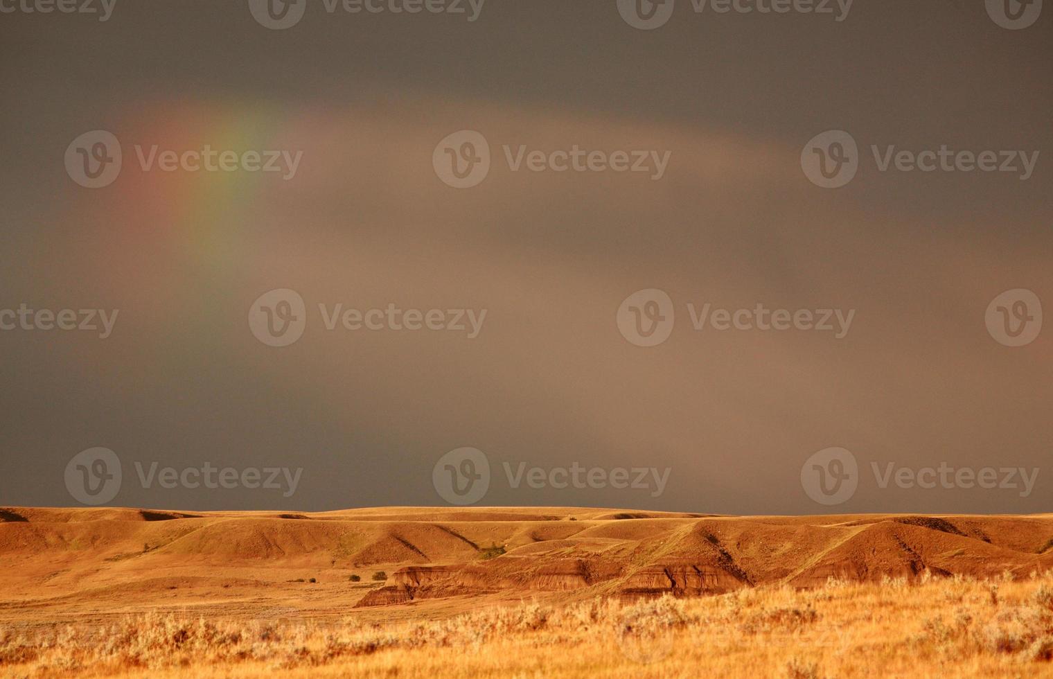 arco-íris parcial sobre o grande vale lamacento de saskatchewan foto
