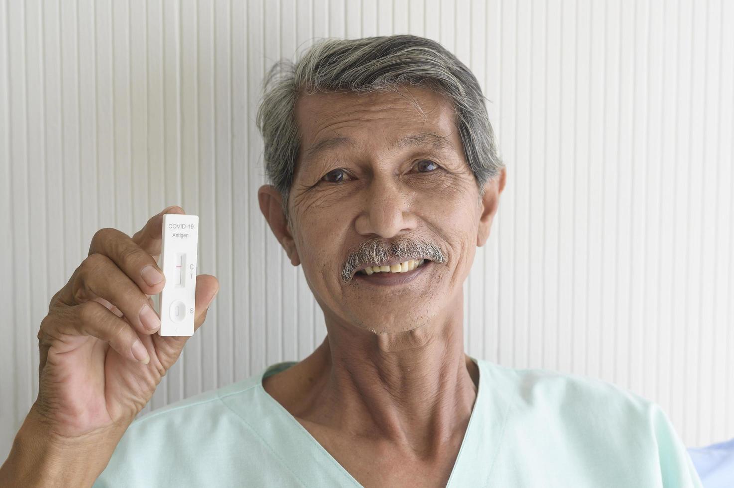 um homem paciente asiático está mostrando resultados do teste covid-19 no hospital foto