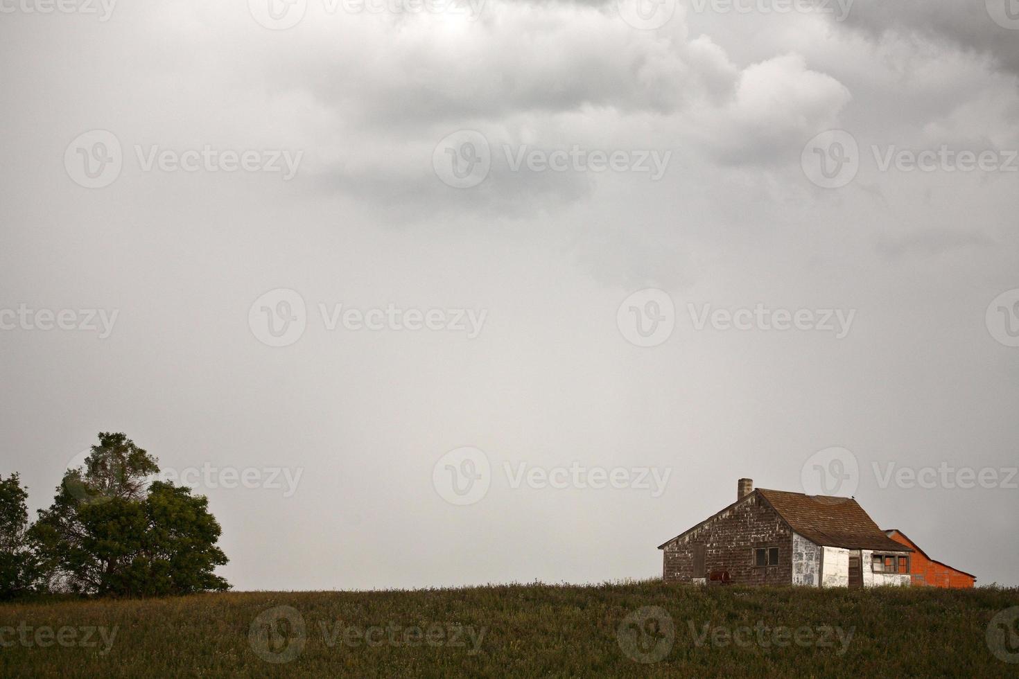 nuvens de tempestade sobre uma casa de fazenda saskatchewan foto