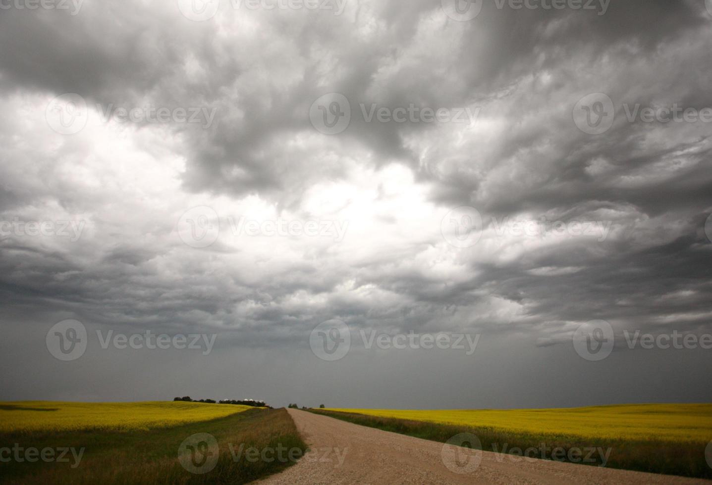 nuvens de tempestade sobre uma estrada rural de saskatchewan foto