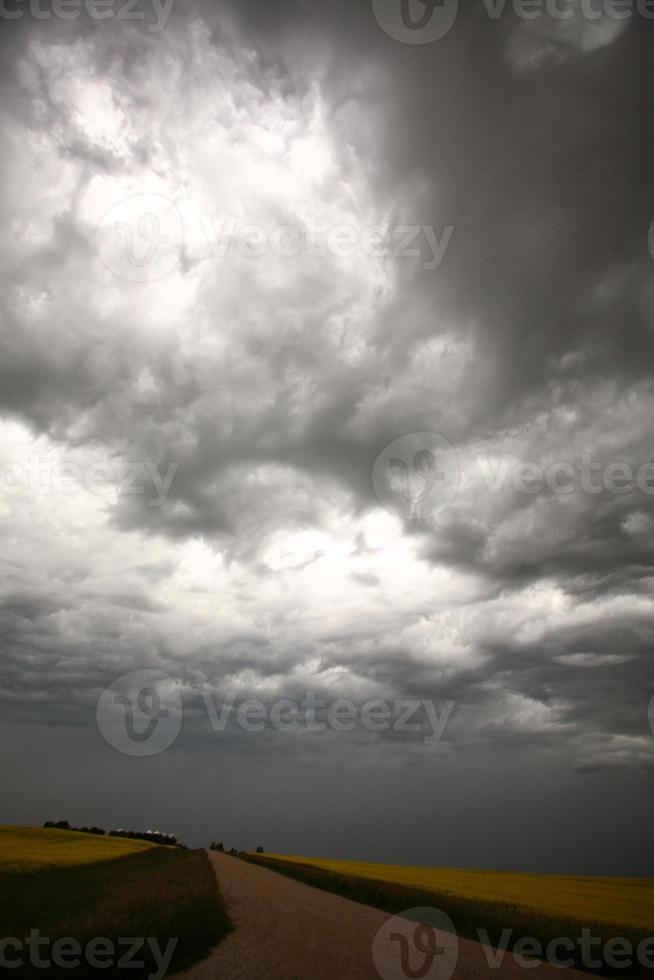 nuvens de tempestade sobre uma estrada rural de saskatchewan foto