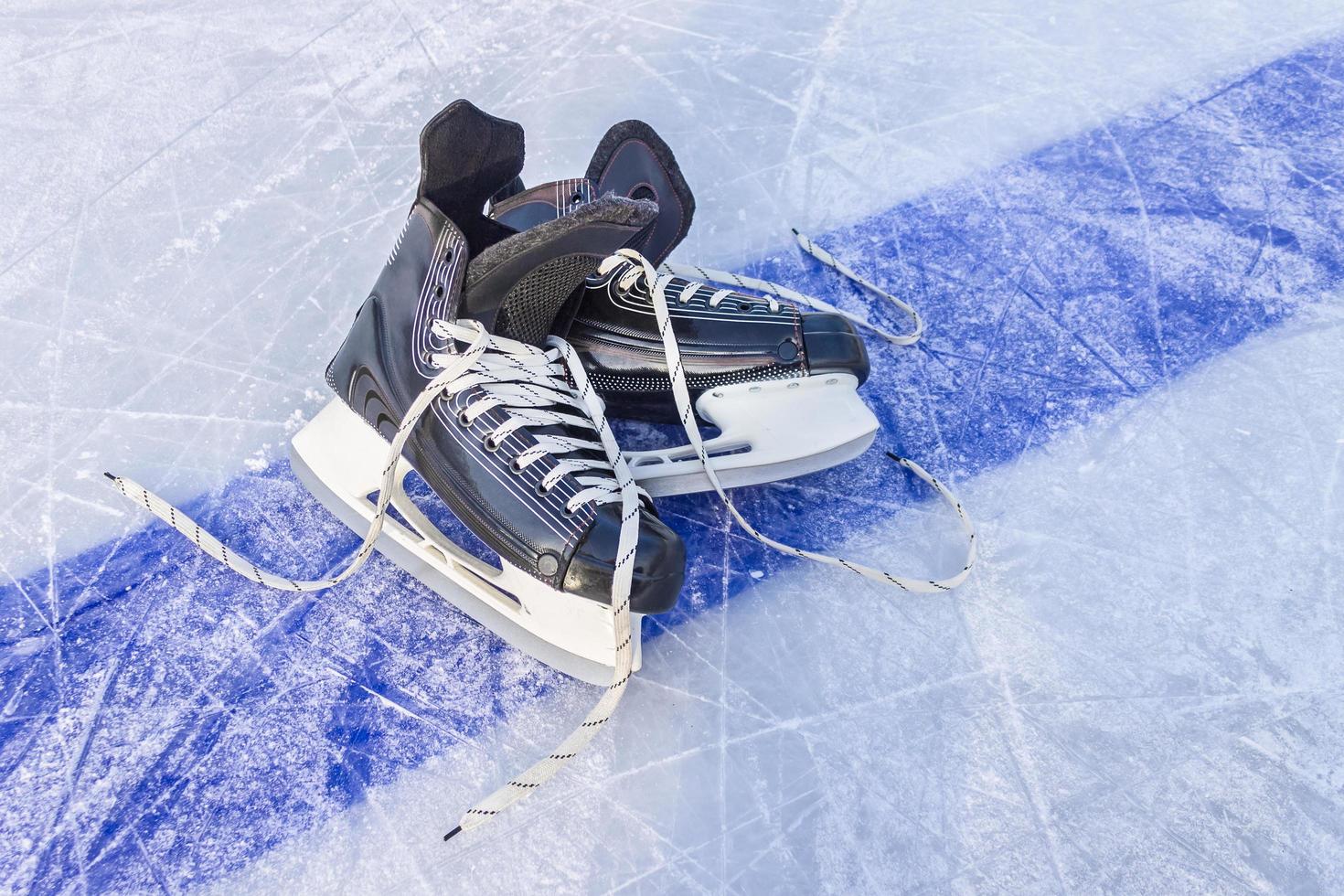 esportes patins pretos estão na quadra de hóquei. equipamentos de esportes de inverno foto