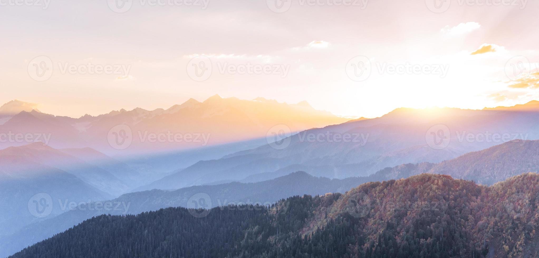 pôr do sol sobre os picos das montanhas cobertas de neve. a vista das montanhas para o monte ushba mheyer, geórgia. Europa foto