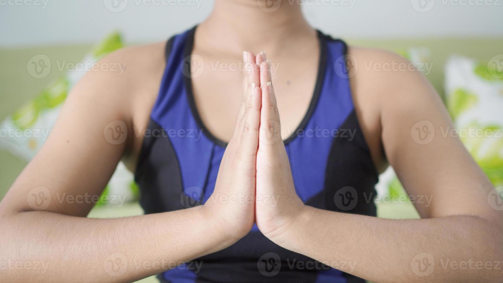 mulher asiática ioga em casa fazendo exercícios de mão com foco foto