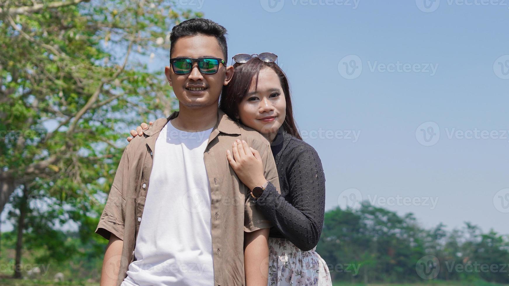 casal jovem feliz apoiando-se um no outro no parque primavera foto