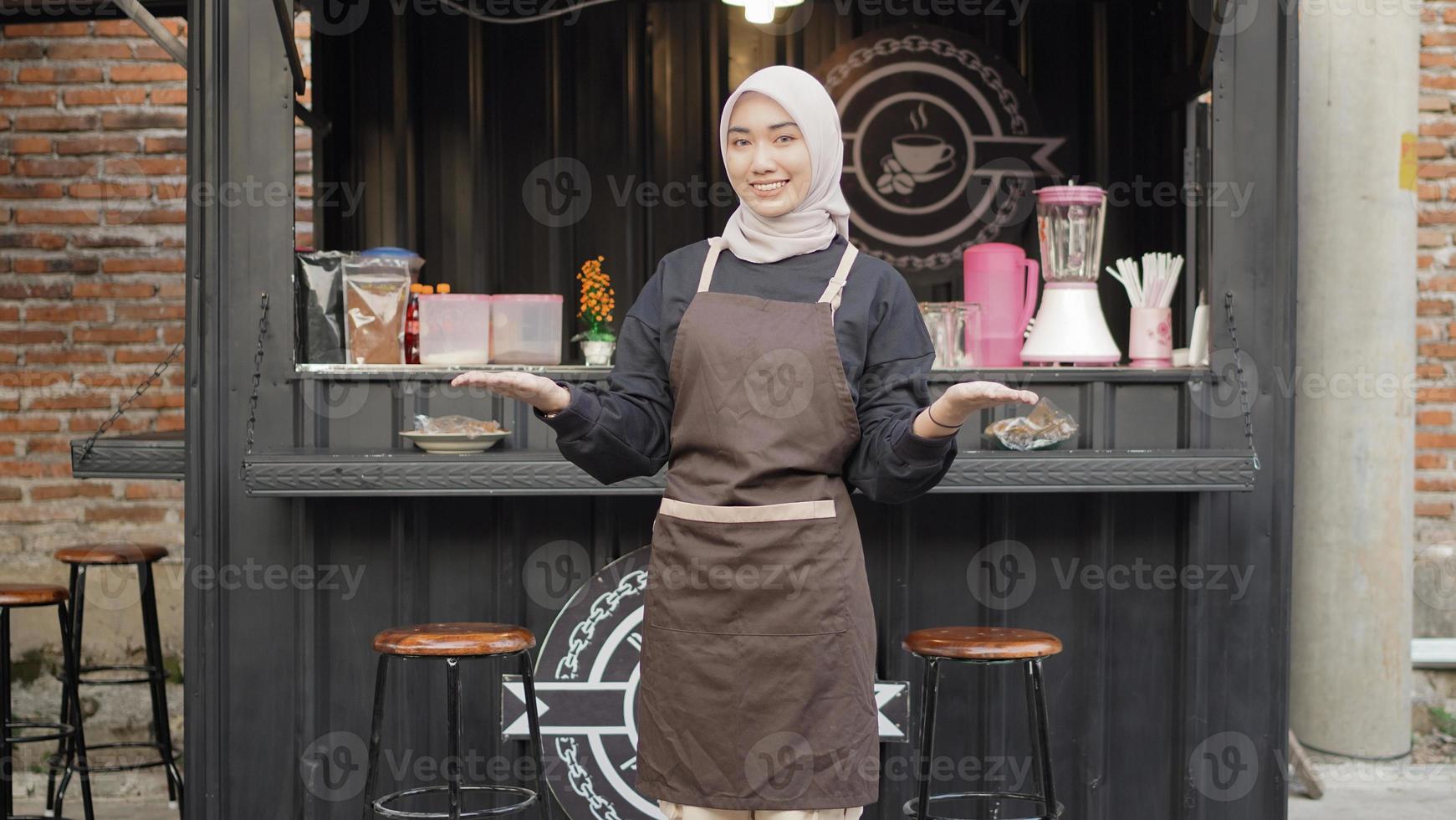 linda garçonete sorridente pronta para receber os clientes no contêiner do estande do café foto