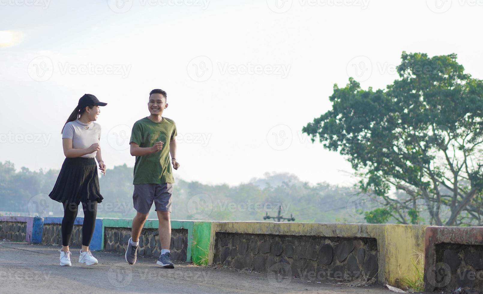 jovem casal asiático em roupas esportivas correndo juntos pela manhã foto