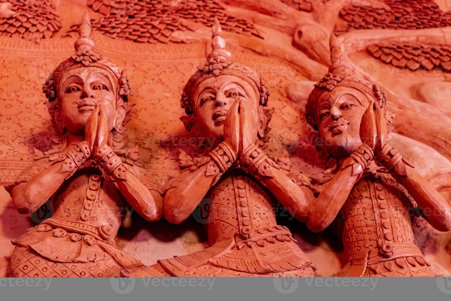 orando nas paredes esculturas templo vermelho wat sila ngu, tailândia. foto