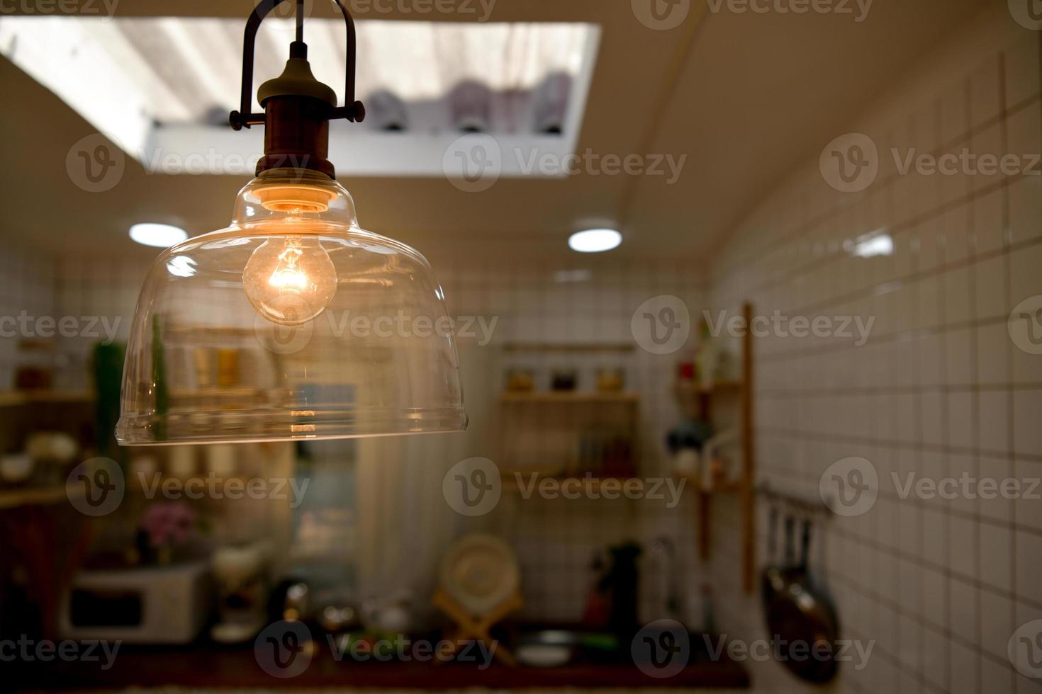 lâmpada amarela que ilumina a cozinha enquanto cozinha. foto