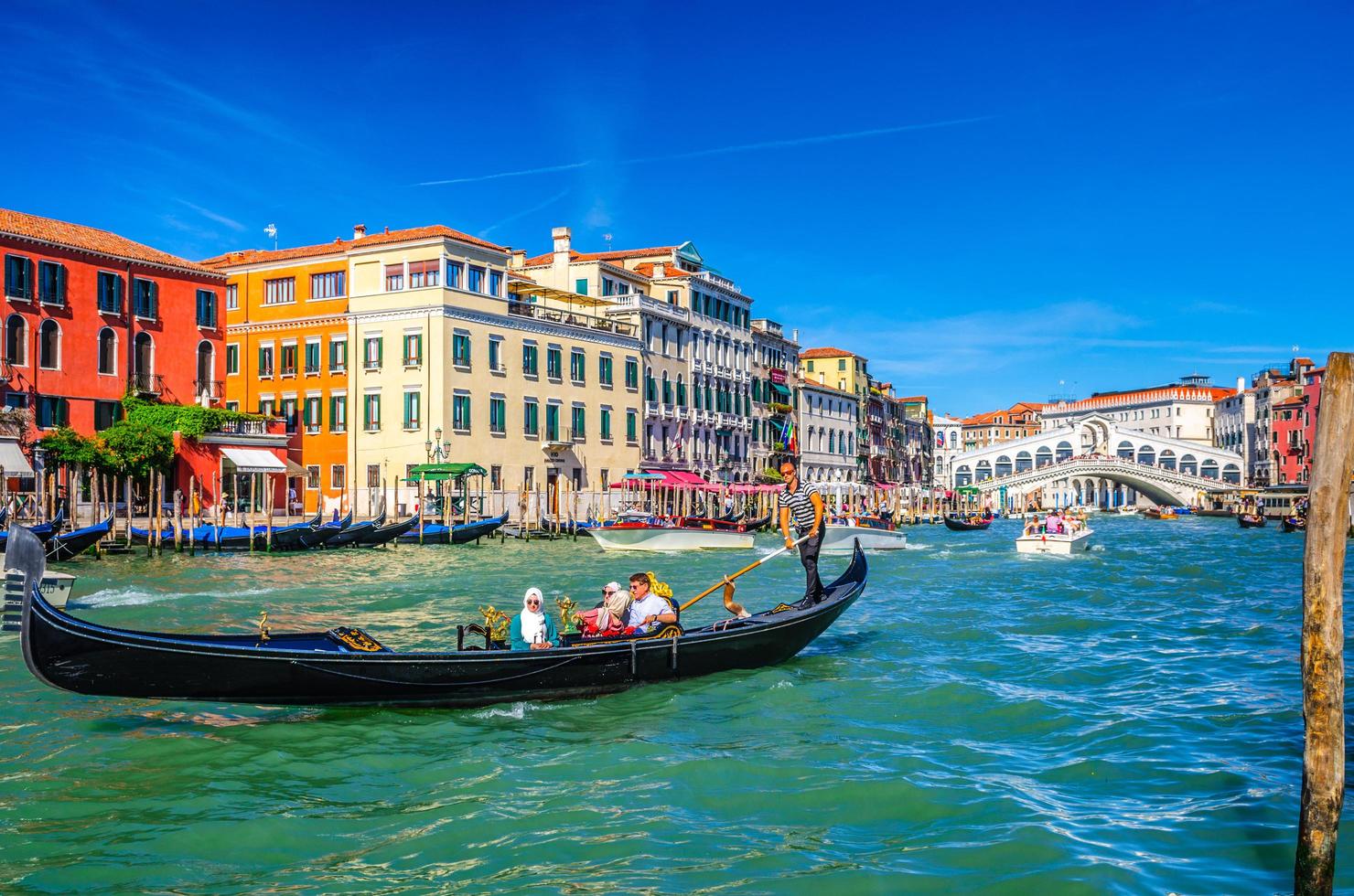 veneza, itália, 13 de setembro de 2019 gondoleiro e turistas na gôndola tradicional barco navegando na água do grande canal em veneza foto