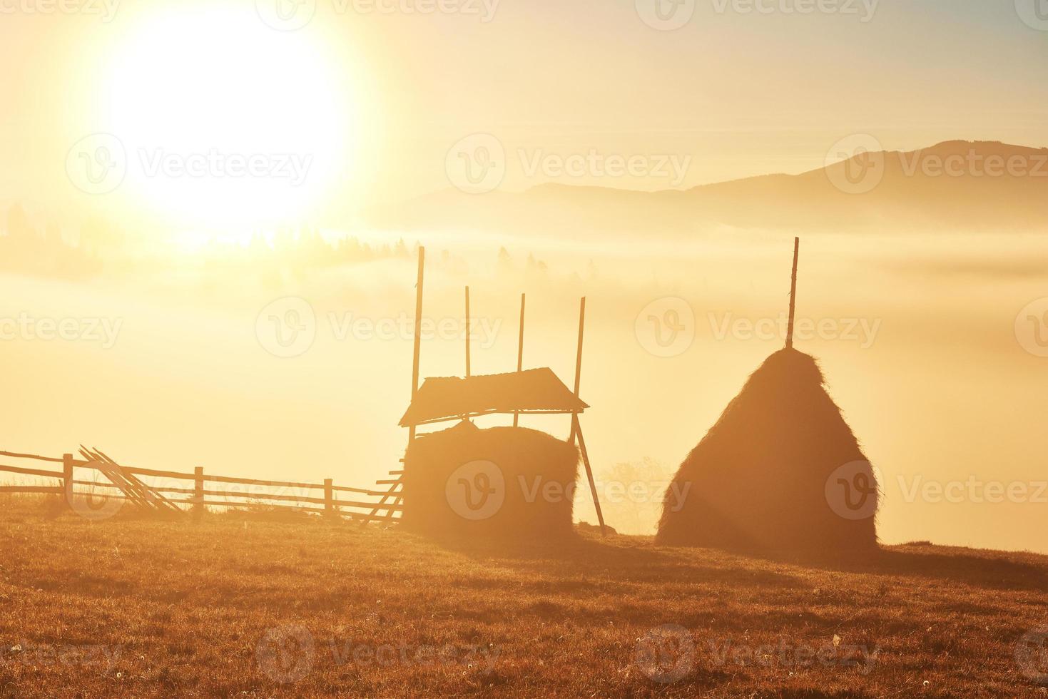 incrível paisagem montanhosa com nevoeiro e um palheiro no outono foto